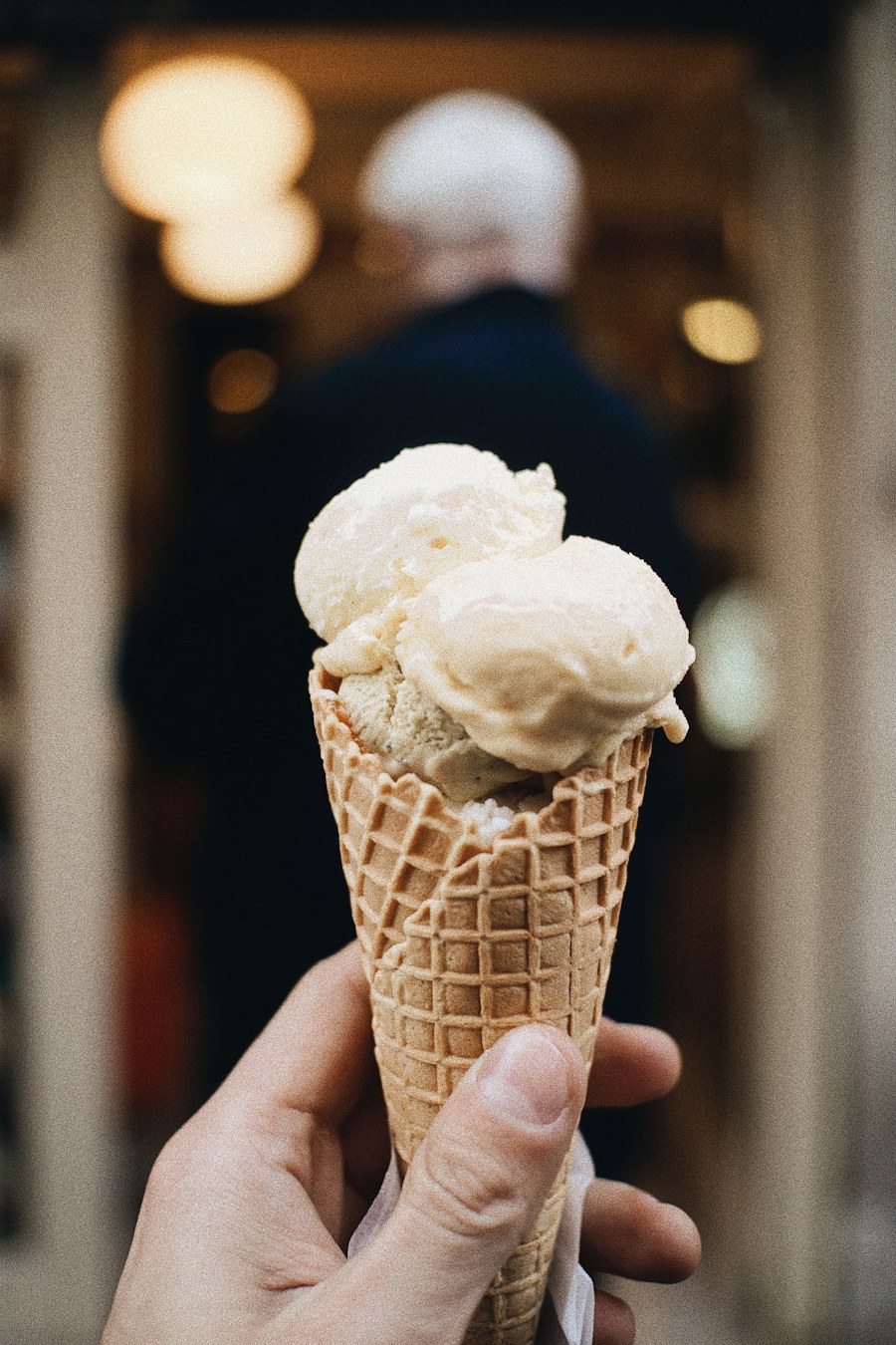 A waffle cone filled with pale gelato