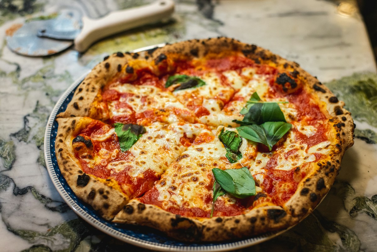 Pizza with melted mozzarella, tomato and fresh basil